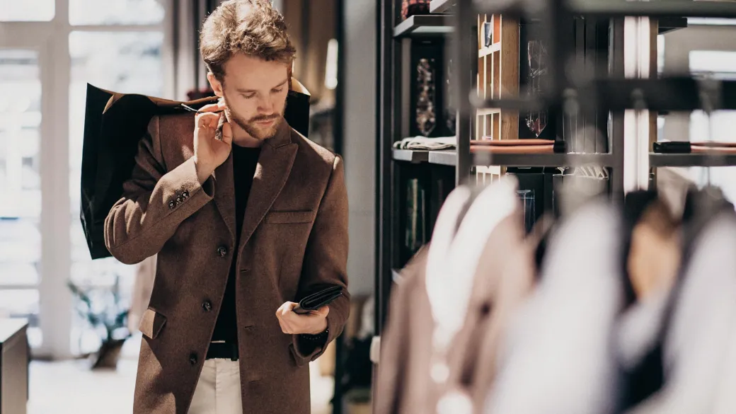 Retail handsome man choosing cloth shop