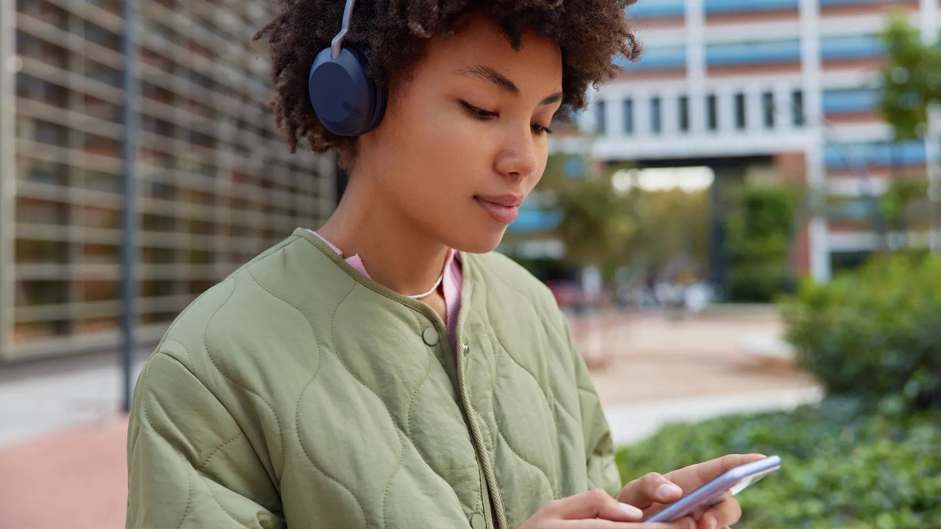 Young woman using mobile and listening to music