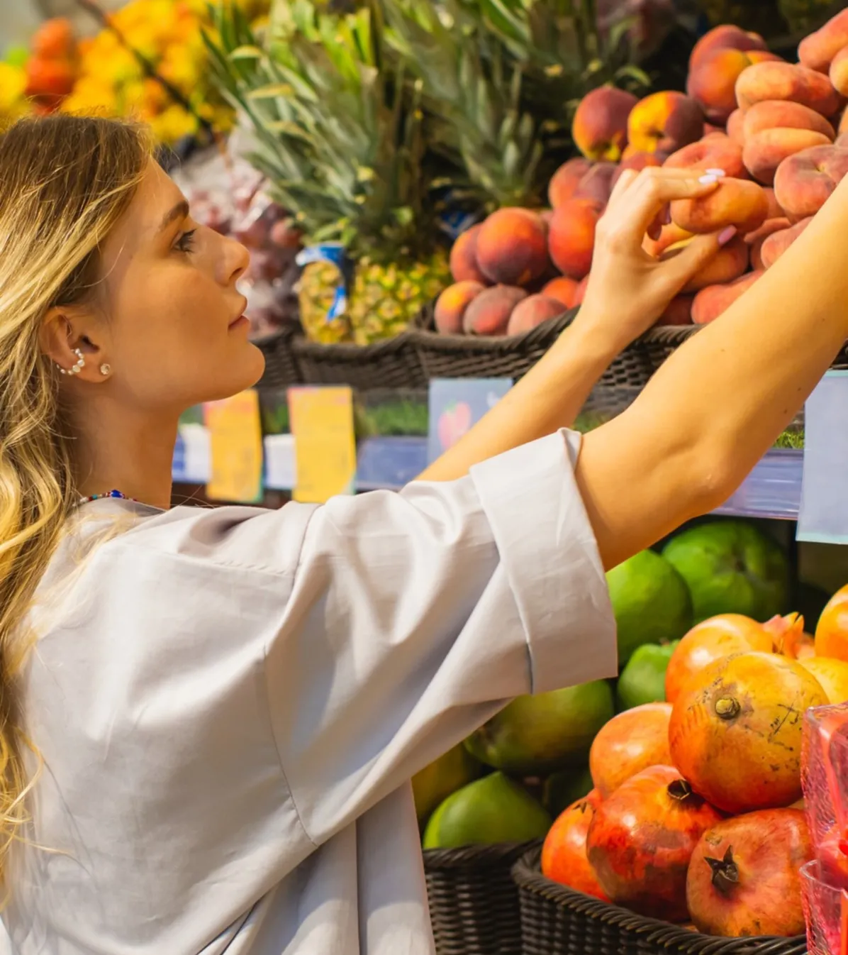 Young woman reaching for produce in grocery store