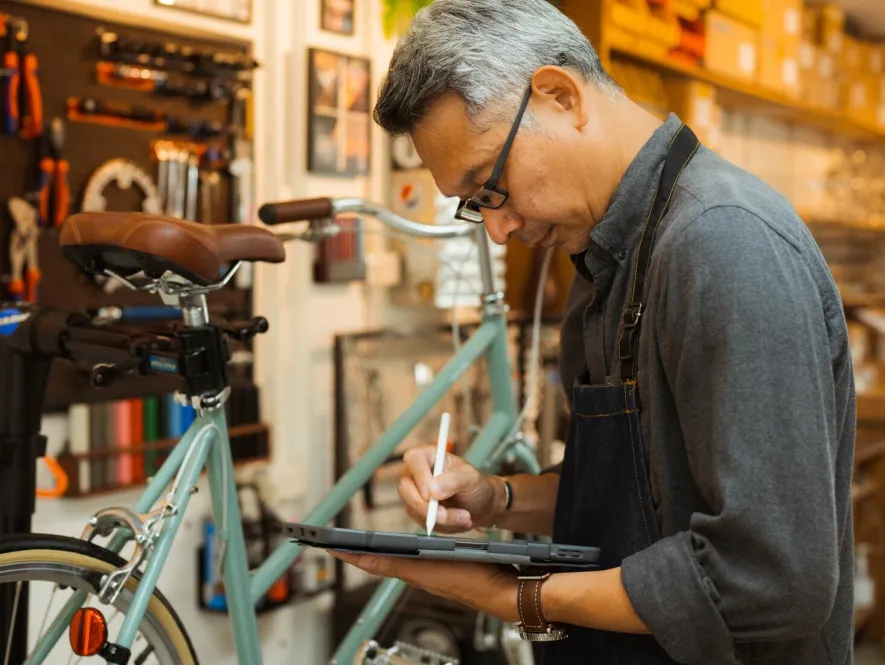 Bikeshop owner looking at tablet